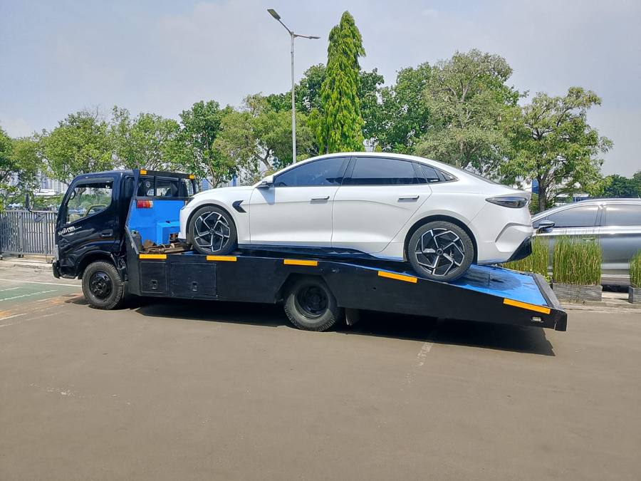 Mobil listrik putih di atas truk towing